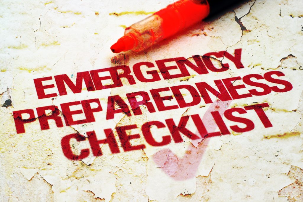 A red marker highlights the words "EMERGENCY PREPAREDNESS CHECKLIST" stenciled in bold red letters on a weathered, textured surface.