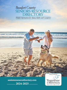 An older man and woman walk and play with a golden retriever on the beach. The cover text reads "Beaufort County Seniors Resource Directory 2024-2025” with helpful information for aging adults and caregivers.